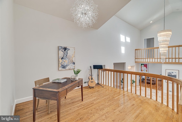 home office with high vaulted ceiling, wood finished floors, baseboards, and a chandelier