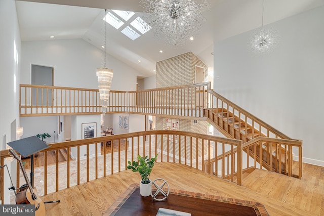 stairs featuring high vaulted ceiling, recessed lighting, wood finished floors, and a chandelier