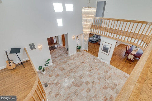 interior space featuring visible vents, baseboards, a high ceiling, and a chandelier