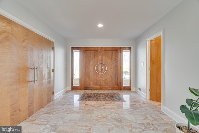 foyer entrance with recessed lighting, baseboards, and marble finish floor