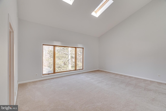 unfurnished room with baseboards, light carpet, high vaulted ceiling, and a skylight