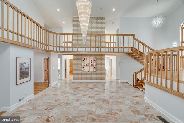 staircase featuring a notable chandelier, baseboards, and visible vents