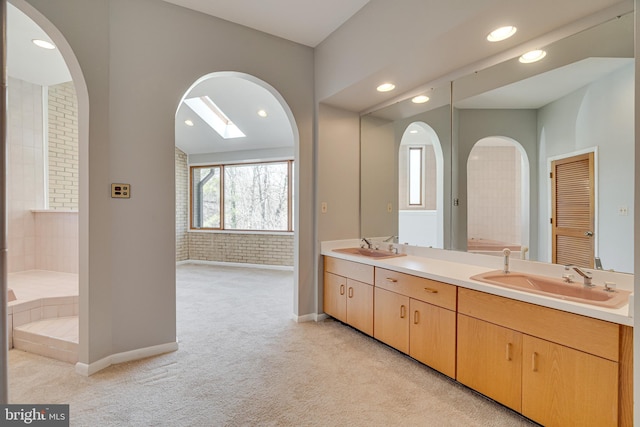 full bath featuring a sink, baseboards, recessed lighting, and double vanity