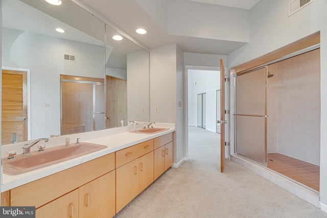 bathroom with a sink, visible vents, double vanity, and a shower stall