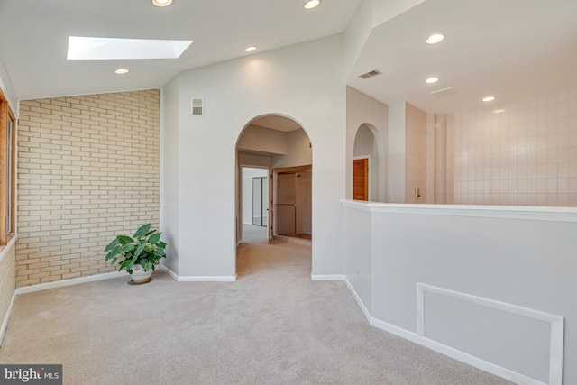 interior space with visible vents, brick wall, recessed lighting, vaulted ceiling, and carpet flooring