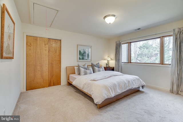 carpeted bedroom featuring visible vents, baseboards, and attic access