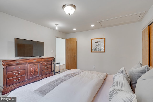 bedroom with attic access, recessed lighting, and a closet