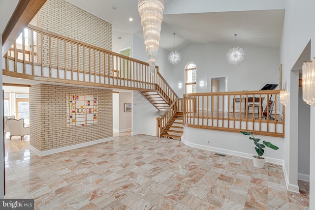 staircase featuring baseboards, a chandelier, and a towering ceiling