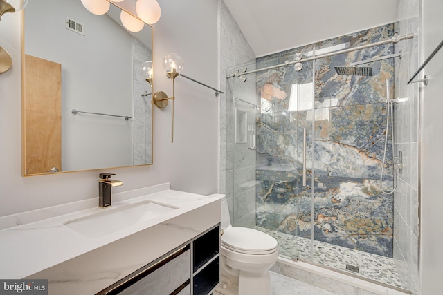 bathroom featuring vanity, toilet, visible vents, and a marble finish shower