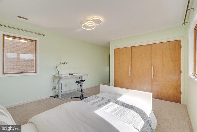 carpeted bedroom with baseboards, visible vents, and a closet