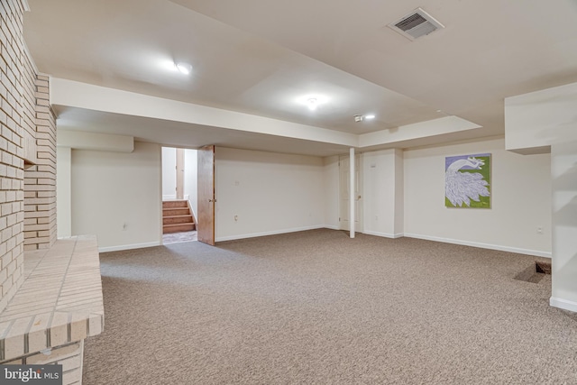 finished basement with stairs, carpet, visible vents, and baseboards