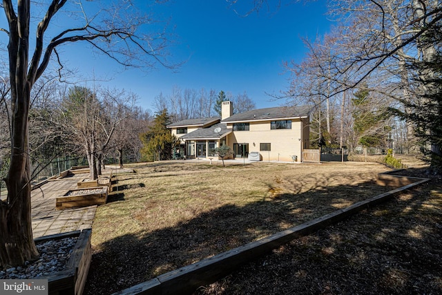 rear view of property featuring a patio area, fence, and a chimney