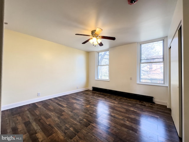 unfurnished room featuring baseboards, ceiling fan, and dark wood-style flooring