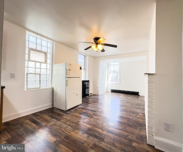 unfurnished living room featuring baseboards, dark wood finished floors, and a ceiling fan