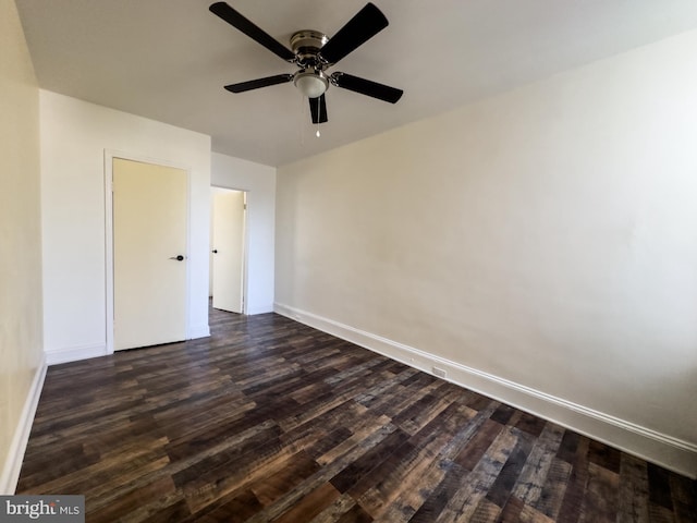 unfurnished bedroom featuring ceiling fan, dark wood-type flooring, and baseboards