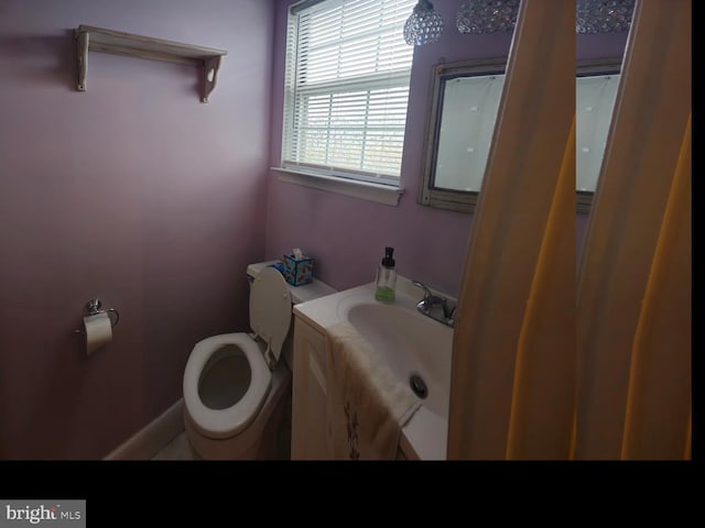 bathroom with baseboards, toilet, and vanity