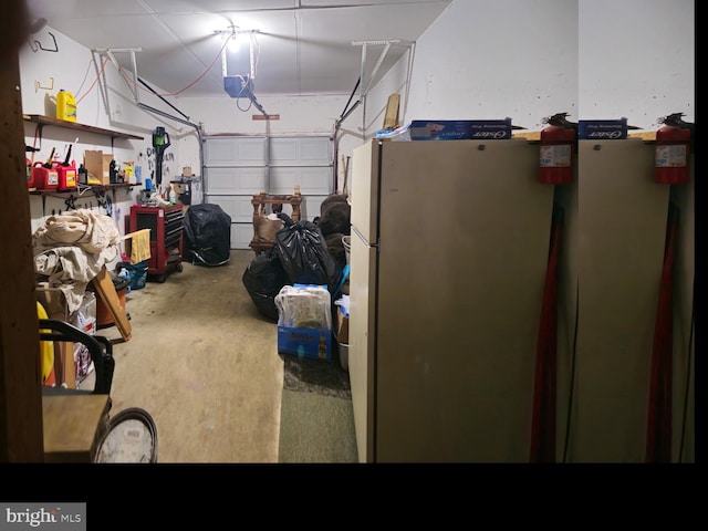 garage with a garage door opener and freestanding refrigerator