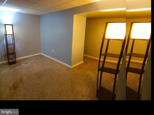 interior space with a paneled ceiling and baseboards