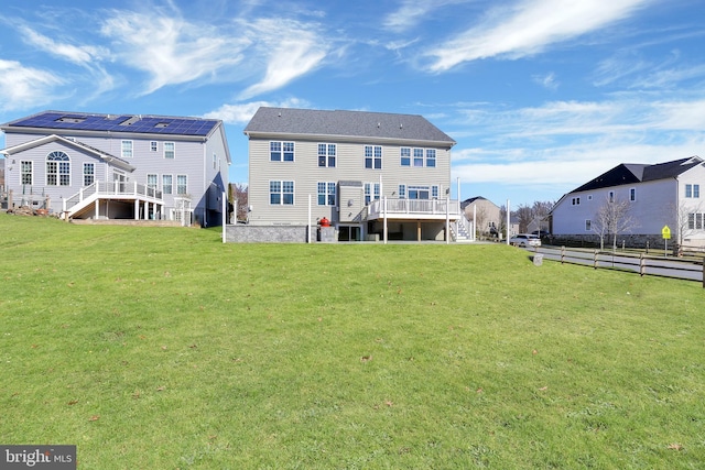 rear view of house featuring a deck, stairs, and a lawn