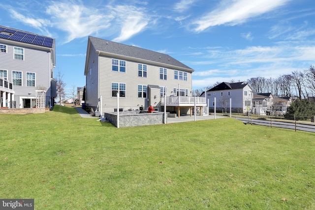 back of property with a patio area, a residential view, and a lawn