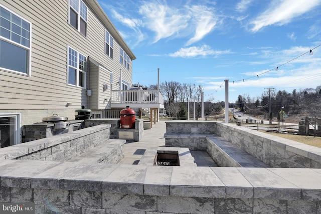 view of patio featuring an outdoor kitchen and a wooden deck