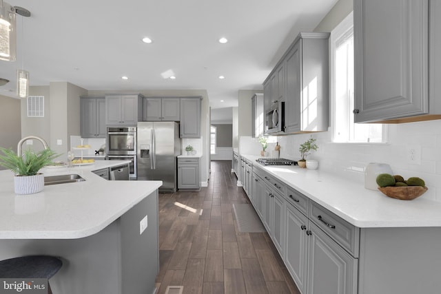 kitchen with dark wood-type flooring, gray cabinetry, visible vents, and stainless steel appliances