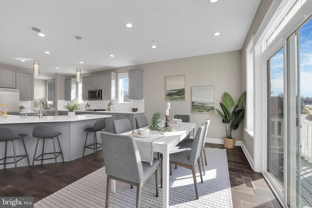 dining space with light wood-style flooring, recessed lighting, and baseboards