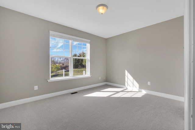 unfurnished room featuring visible vents, carpet floors, and baseboards