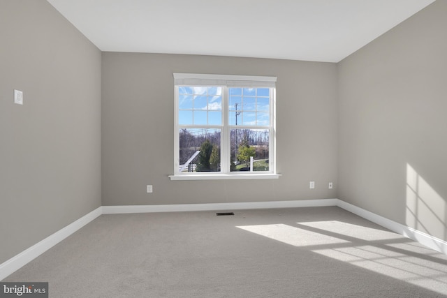 carpeted empty room featuring visible vents and baseboards