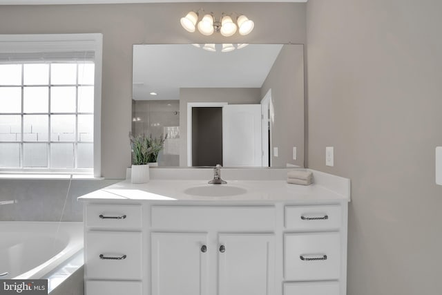 full bath with vanity, a garden tub, and a shower