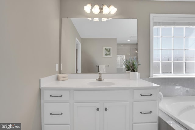 bathroom featuring a garden tub and vanity