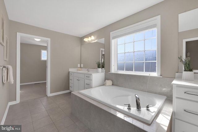 full bathroom with tile patterned floors, baseboards, a garden tub, and vanity