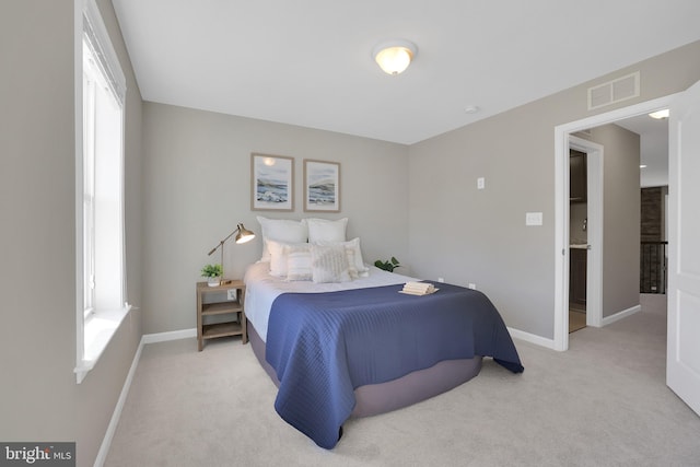 carpeted bedroom featuring baseboards and visible vents