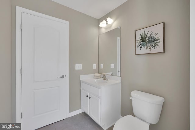 half bath featuring vanity, tile patterned floors, and toilet