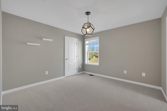 carpeted spare room with baseboards and visible vents