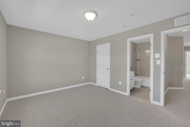 unfurnished bedroom with visible vents, light colored carpet, ensuite bathroom, and baseboards