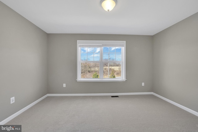 unfurnished room featuring visible vents, carpet, and baseboards