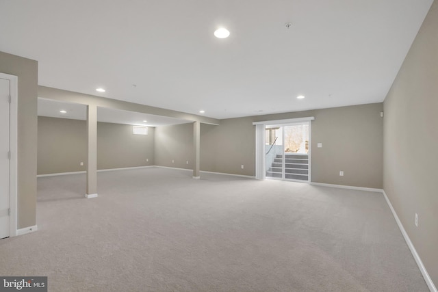 basement featuring light carpet, recessed lighting, stairs, and baseboards