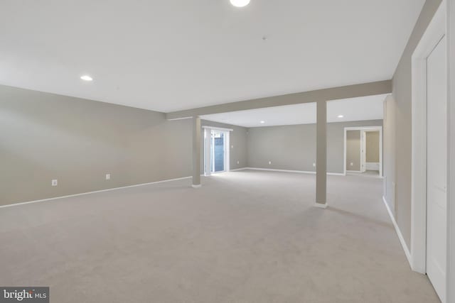 below grade area with light carpet, recessed lighting, and baseboards