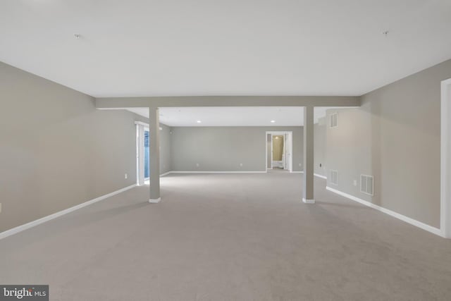 empty room featuring visible vents, baseboards, and light carpet