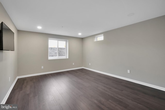 basement featuring recessed lighting, baseboards, and dark wood-style floors