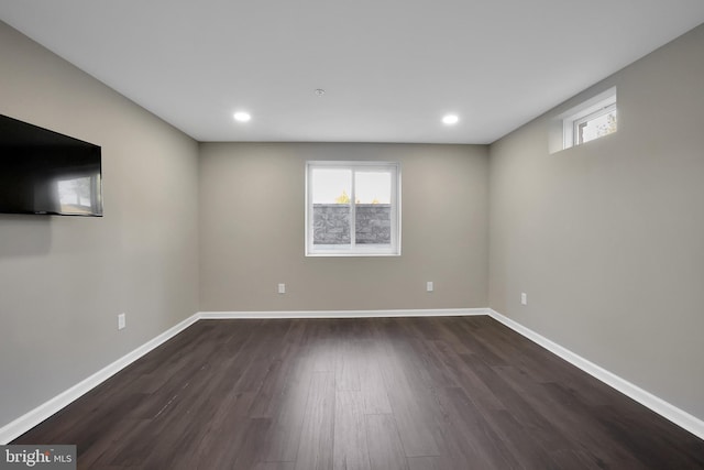 basement featuring plenty of natural light, baseboards, and dark wood-style flooring