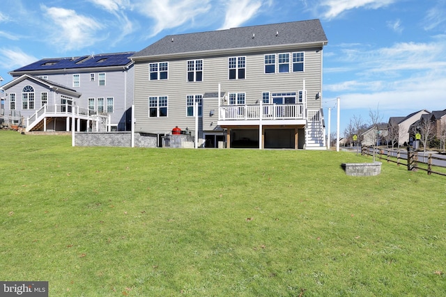 back of property featuring a lawn, stairs, a deck, and fence