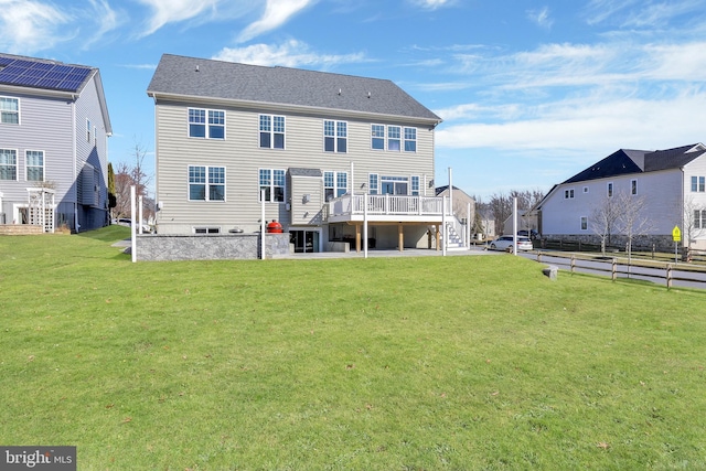 rear view of house featuring a patio area, a lawn, a wooden deck, and stairs