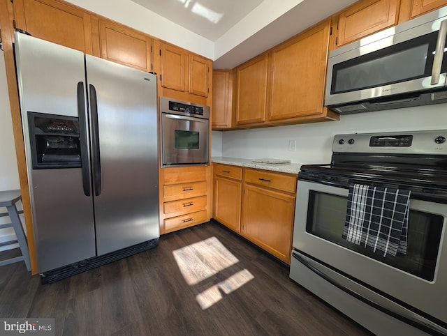 kitchen with brown cabinetry, appliances with stainless steel finishes, and dark wood-style flooring