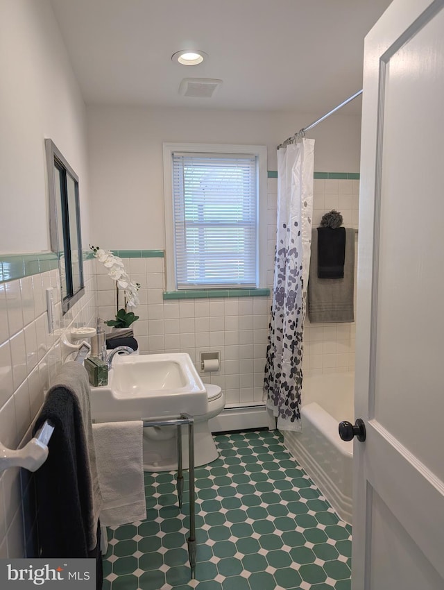 full bathroom with visible vents, shower / tub combo with curtain, toilet, tile walls, and baseboard heating