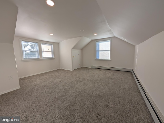 additional living space featuring a baseboard heating unit, carpet, a baseboard radiator, baseboards, and vaulted ceiling