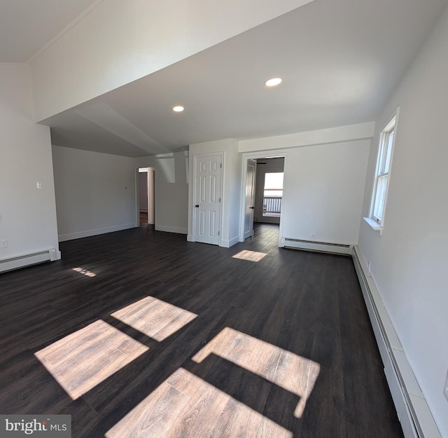 unfurnished living room featuring baseboard heating, dark wood-type flooring, baseboards, and a baseboard radiator