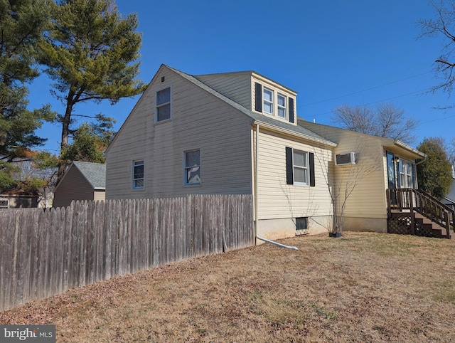 view of side of property featuring a lawn and fence