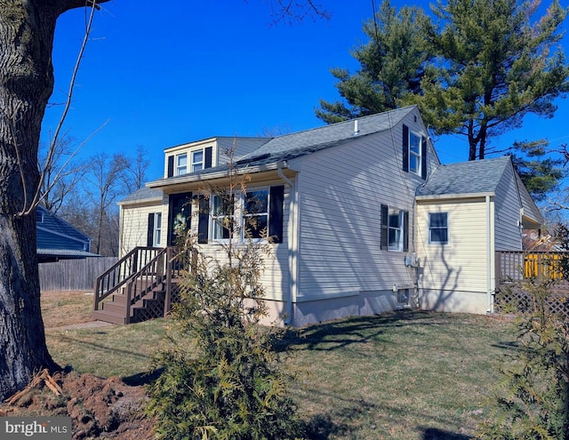 bungalow featuring a shingled roof, a front lawn, and fence